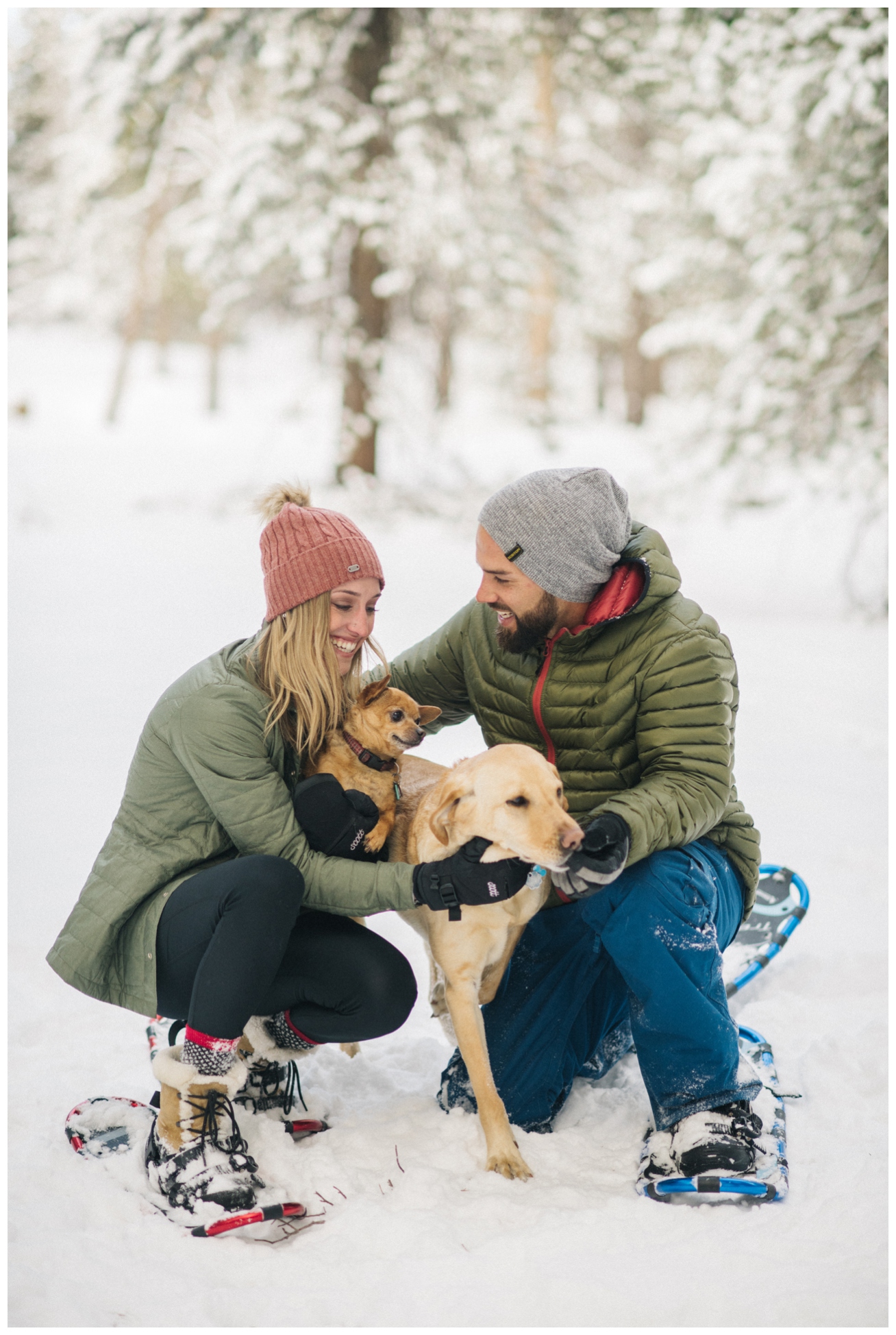 engaged couple in snow with dog
