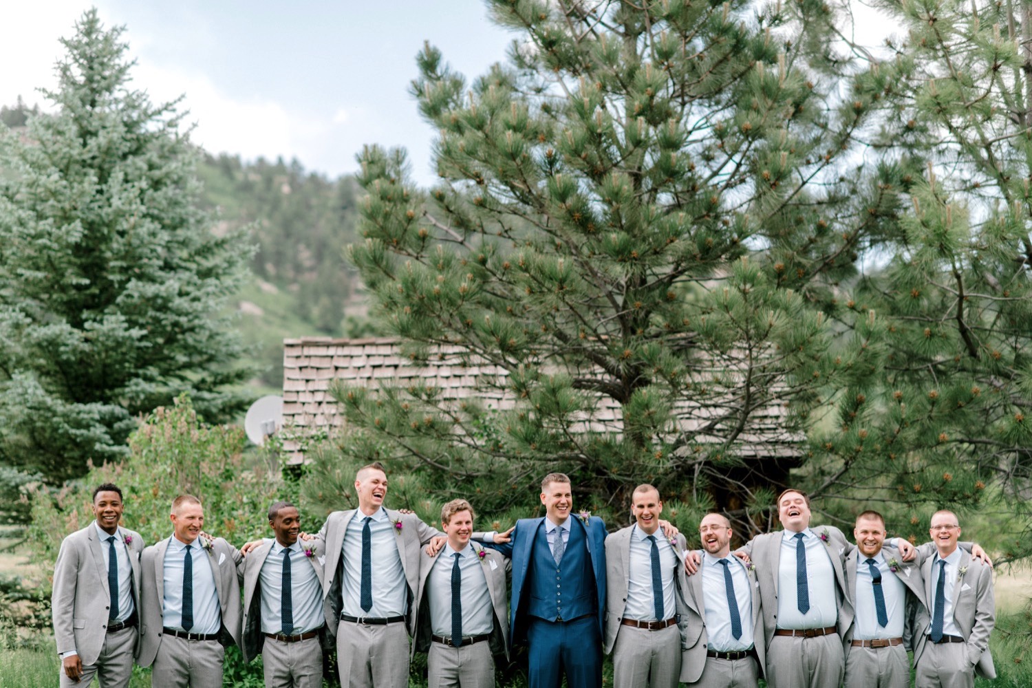 Charlton surrounded by his groomsmen poses for portraits outside Spruce Mountain Ranch in Larkspur, Colorado.