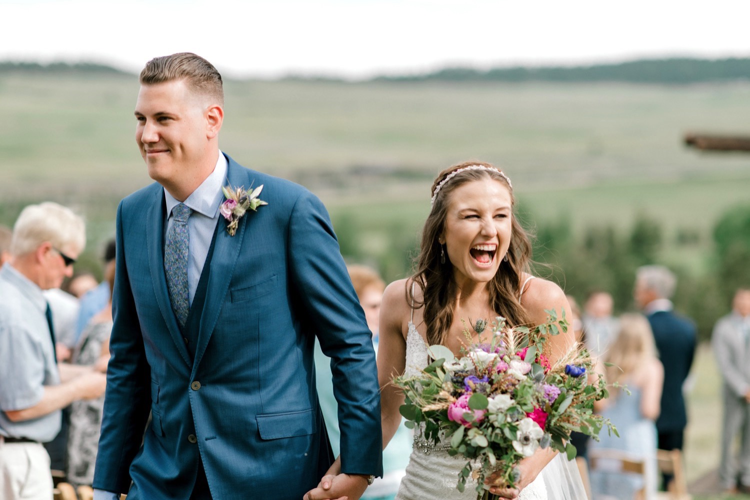 Kristen and Charlton cheer as they're married and walk down the aisle for their recessional at Spruce Mountain Ranch in Larkspur, Colorado.