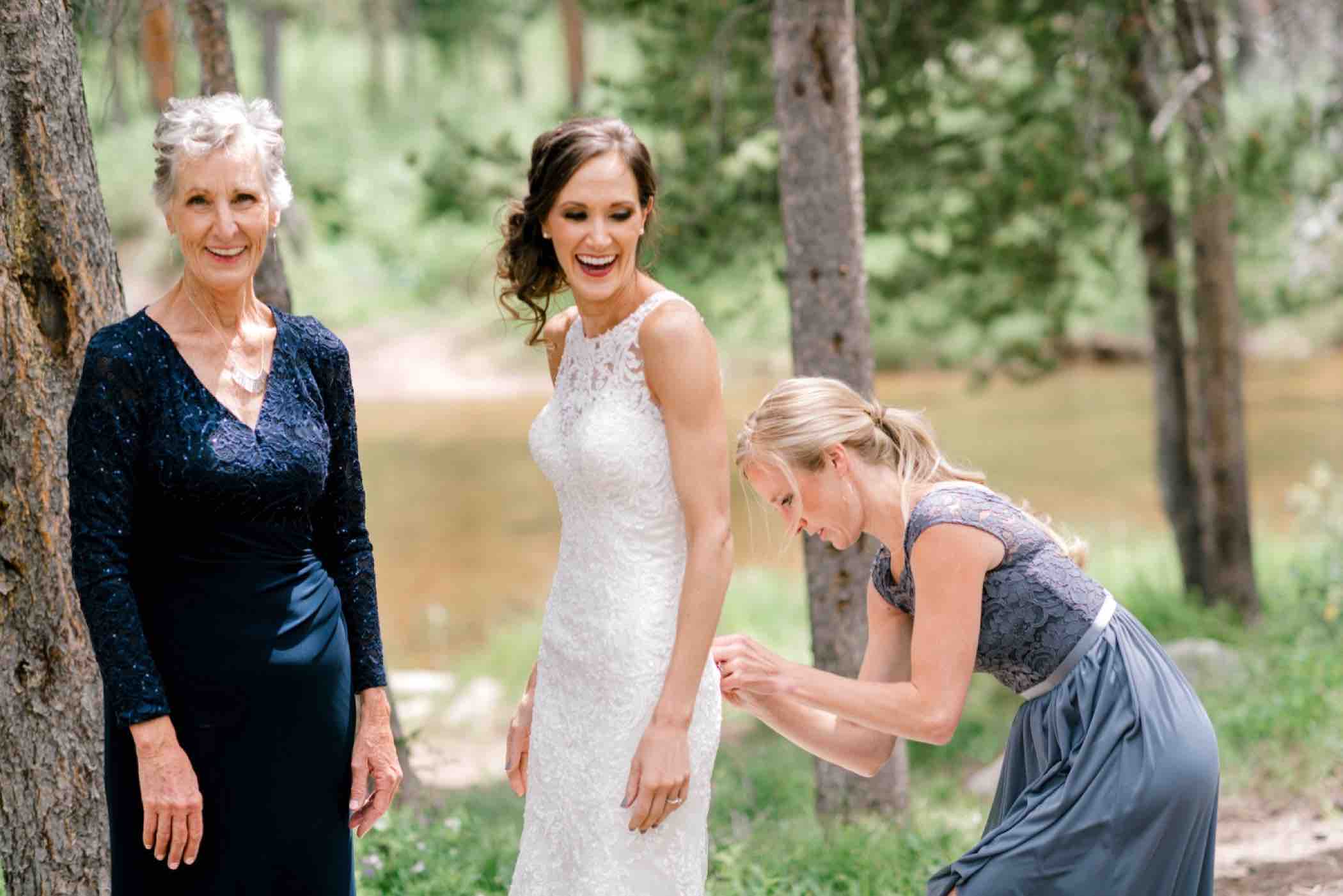 Sallie putting her wedding dress outside at Piney River Ranch in Vail, Colorado. Photo by Ali and Garrett, Romantic, Adventurous, Nostalgic Wedding Photographers.