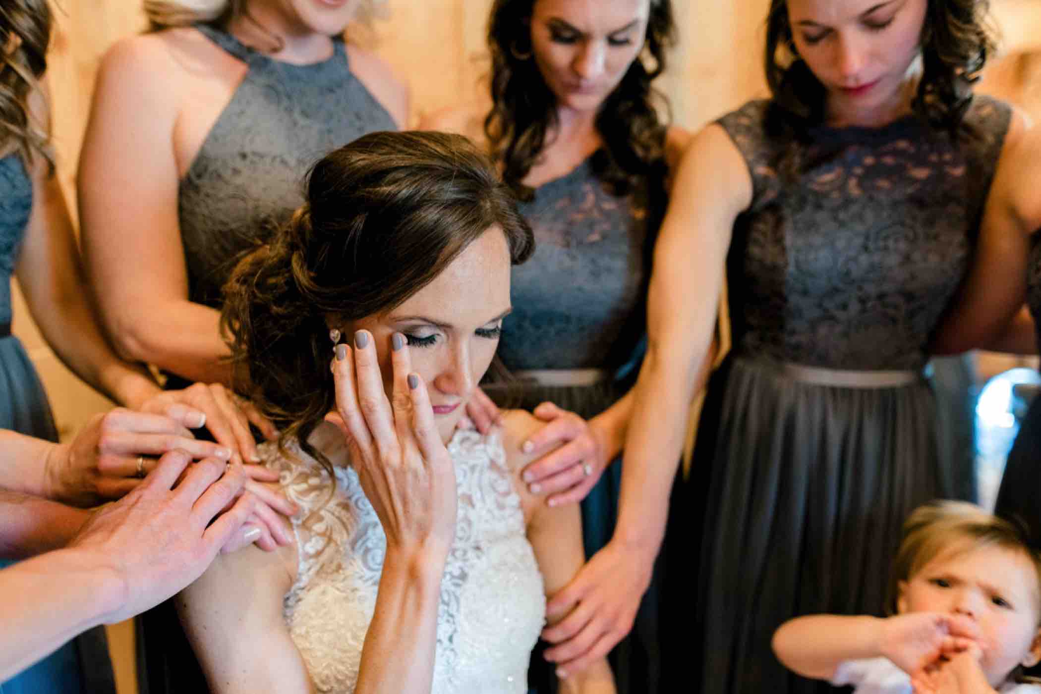 Sallie's bridesmaid surround her in prayer before her wedding at Piney River Ranch in Vail, Colorado. Photo by Ali and Garrett, Romantic, Adventurous, Nostalgic Wedding Photographers.