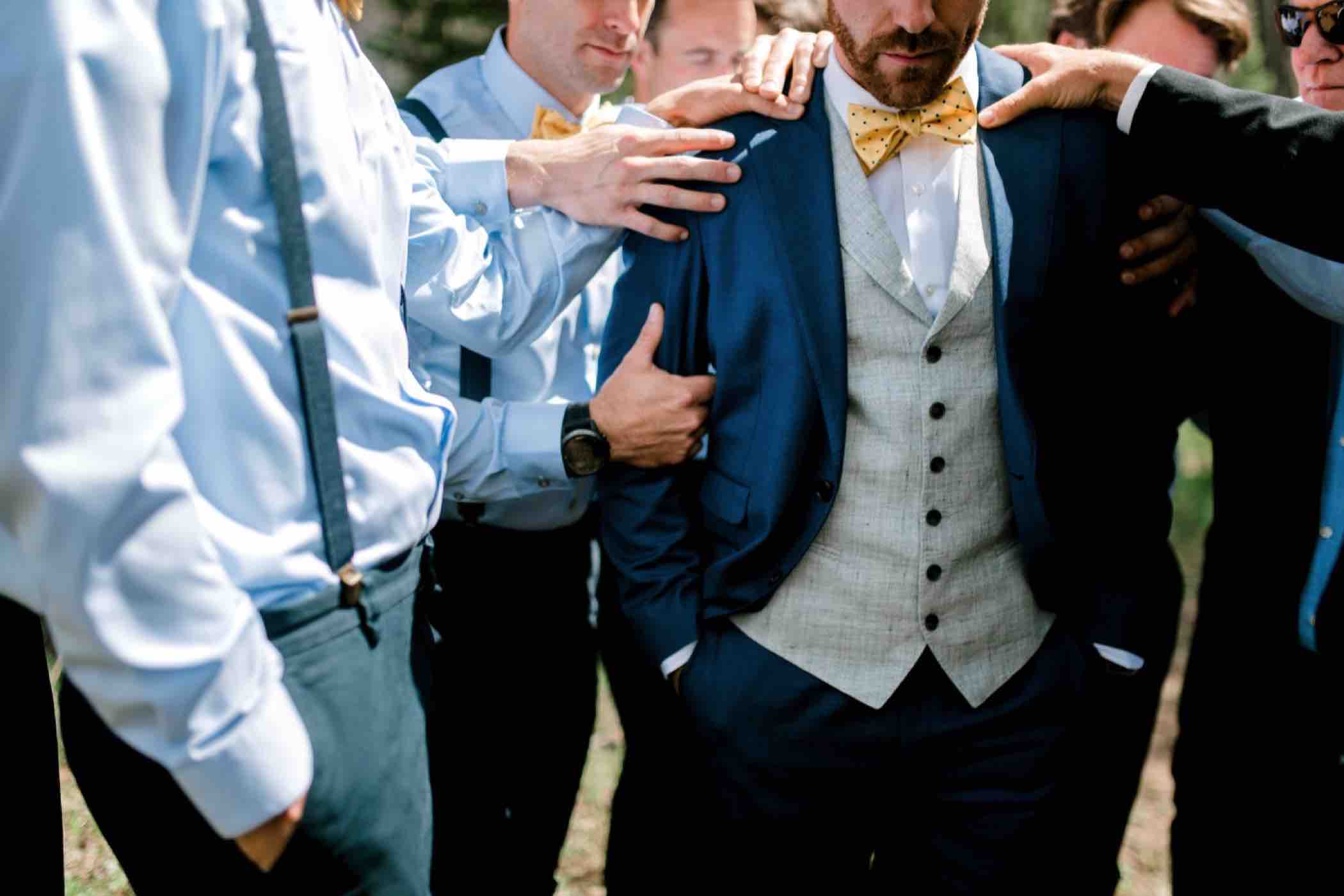 Groomsmen pray over the groom outside Piney River Ranch in Vail in the Colorado Rocky Mountains. Photo by Ali and Garrett, Romantic, Adventurous, Nostalgic Wedding Photographers.