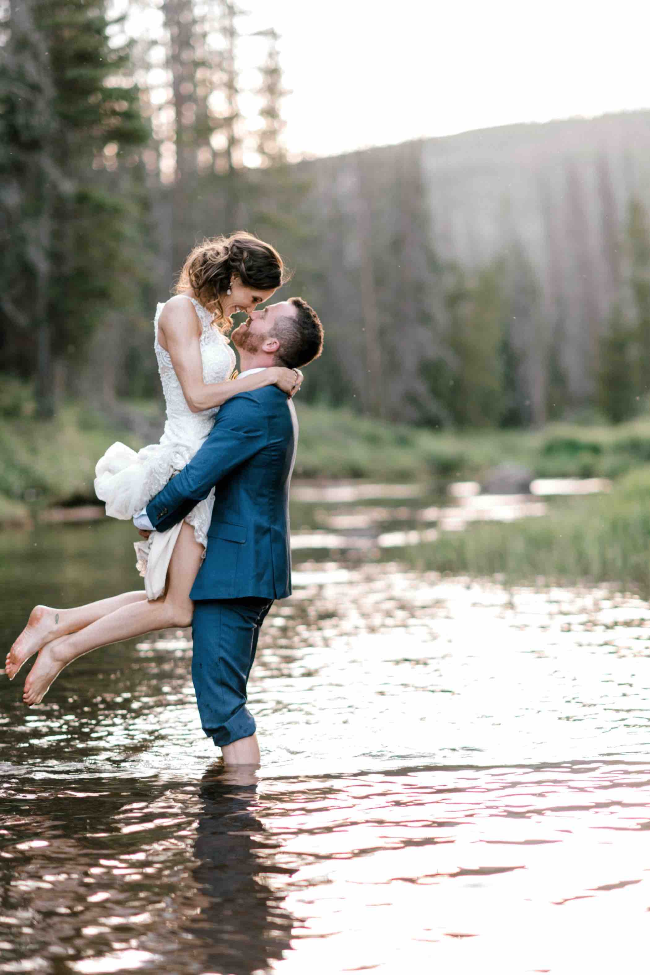 Kris and Sallie chose to take their bride and groom portraits in the water of Piney Lake at Piney River Ranch in Vail, Colorado. Photo by Ali and Garrett, Romantic, Adventurous, Nostalgic Wedding Photographers.