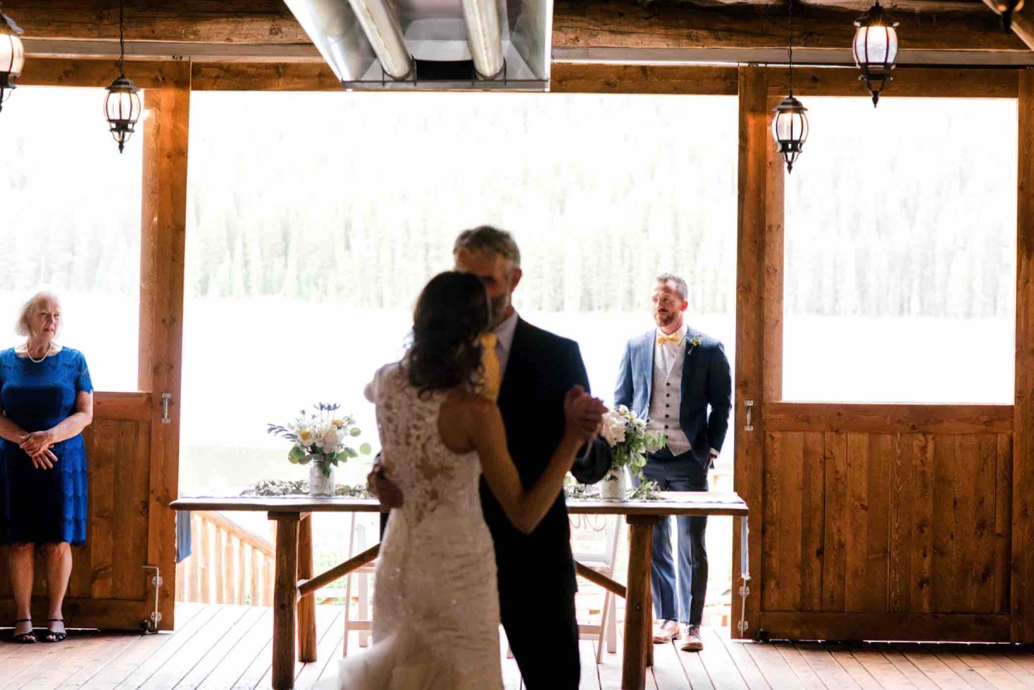 The groom looks on during the father daughter dance at Piney River Ranch in Vail, Colorado. Photo by Ali and Garrett, Romantic, Adventurous, Nostalgic Wedding Photographers.
