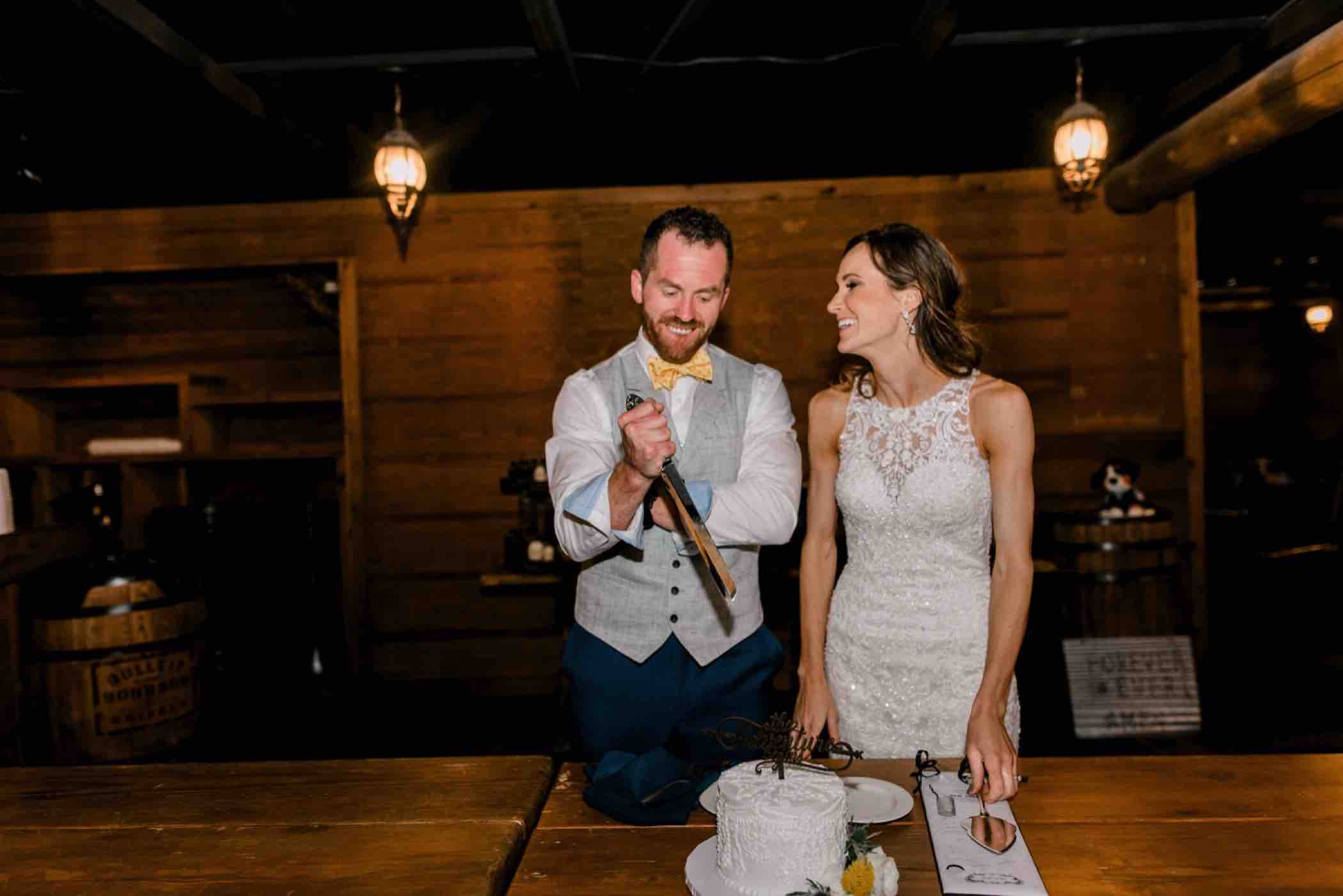 Kris and Sallie get ready to cut the cake at their wedding reception at Piney River Ranch in Vail, Colorado. Photo by Ali and Garrett, Romantic, Adventurous, Nostalgic Wedding Photographers.
