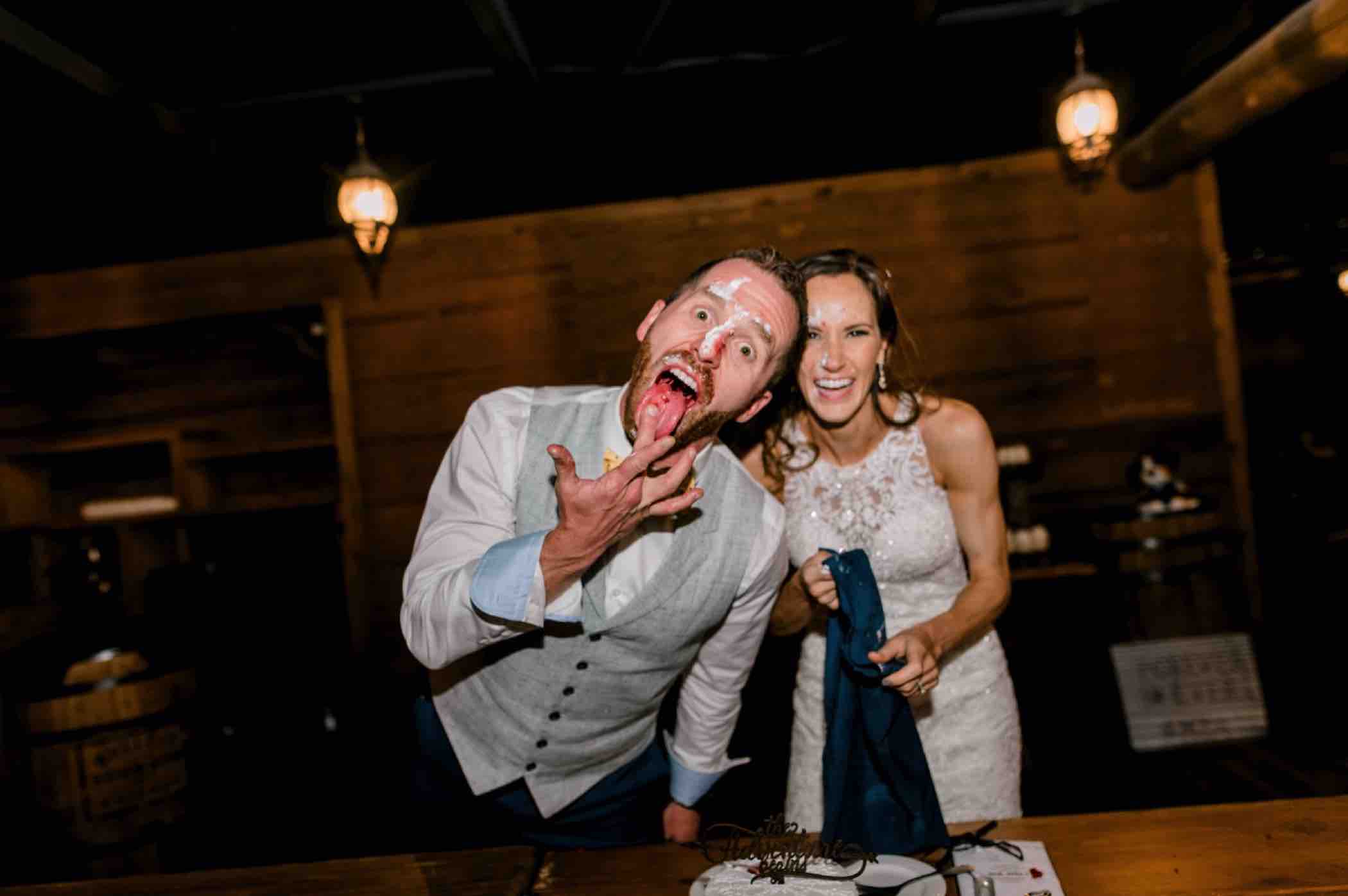 Bride and groom celebrate cutting their cake and smashing it into each other's faces at Piney River Ranch in Vail, Colorado. Photo by Ali and Garrett, Romantic, Adventurous, Nostalgic Wedding Photographers.