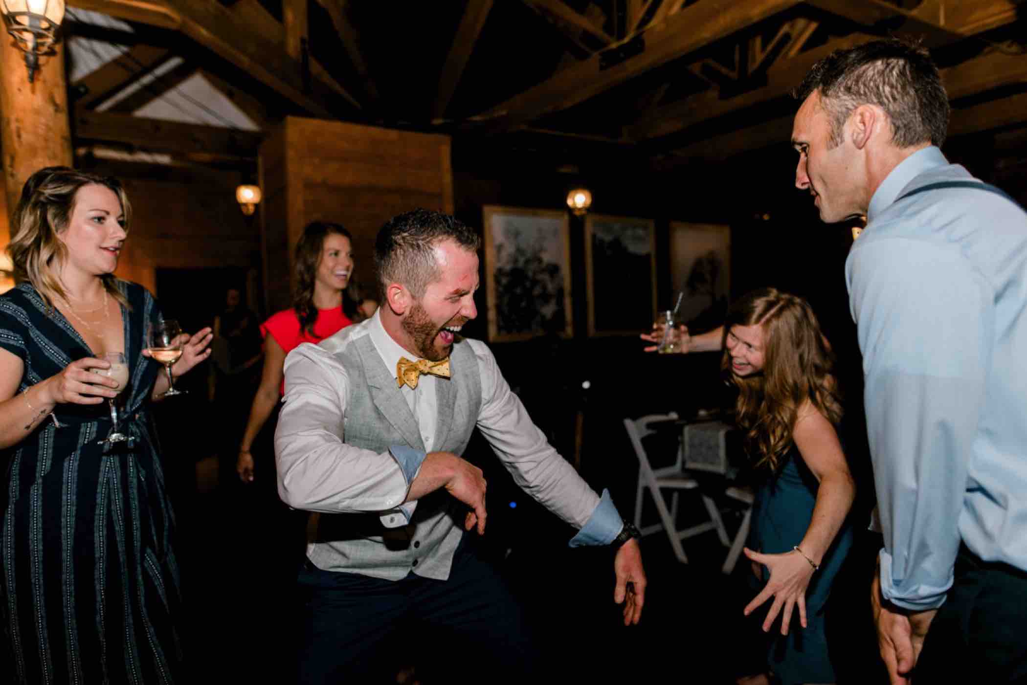 The groom dances with guests at their wedding reception at Piney River Ranch in the Colorado Rocky Mountains. Photo by Ali and Garrett, Romantic, Adventurous, Nostalgic Wedding Photographers.