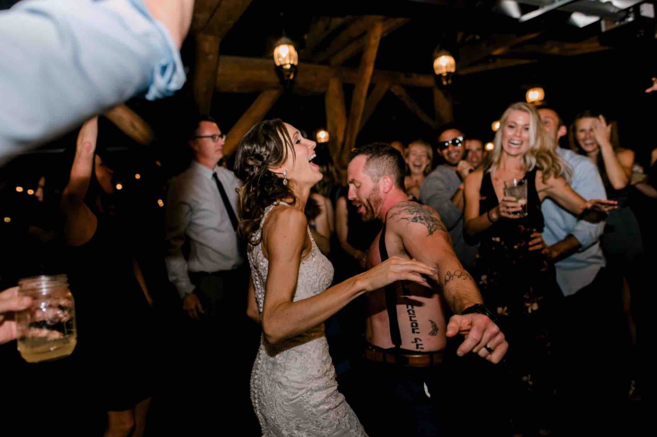 The groom surprised the bride by returning to their wedding reception at Piney River Ranch in Vail, Colorado shirtless. Photo by Ali and Garrett, Romantic, Adventurous, Nostalgic Wedding Photographers.