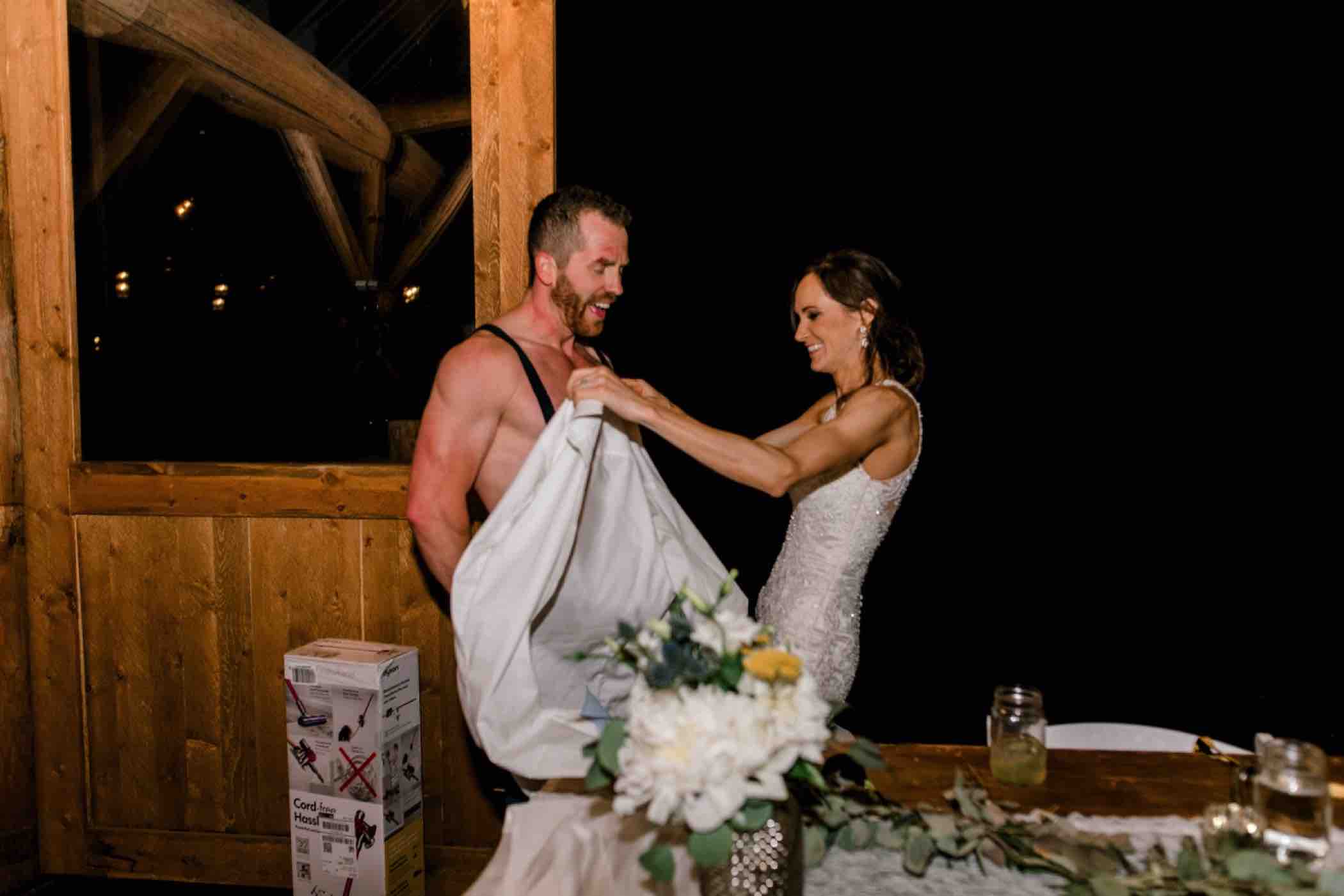 Sallie tries to cover up Kris during their wedding reception at Piney River Ranch in Vail, Colorado. Photo by Ali and Garrett, Romantic, Adventurous, Nostalgic Wedding Photographers.
